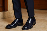 Shiny blue dress shoes worn with dark pants on a wooden floor. Elevated shoes for him. Scarpe rialzate uomo
