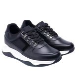 Black sneakers with white soles on a light gray background