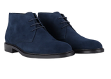 Pair of elevated blue suede shoes on a white background