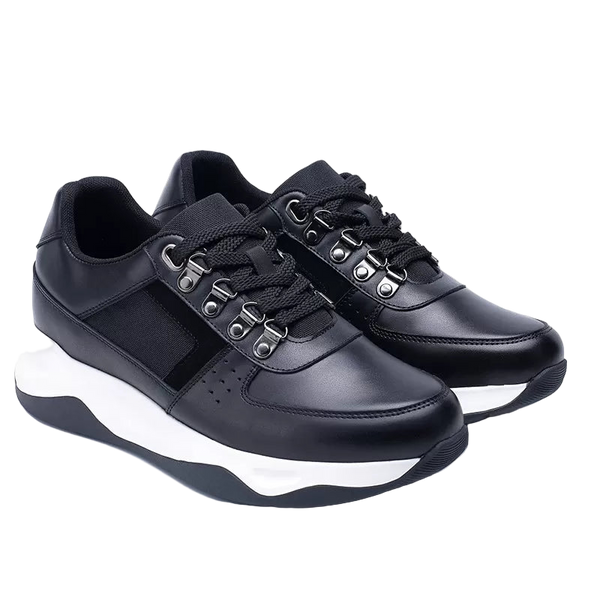 Black sneakers with white soles on a light gray background